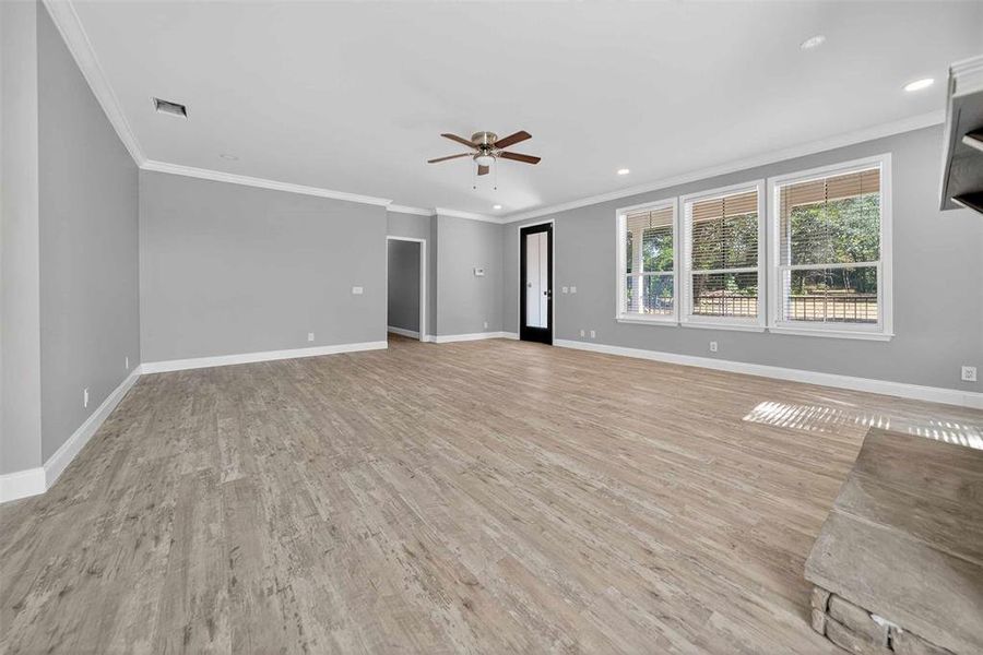 Unfurnished living room featuring ornamental molding, light wood-type flooring, recessed lighting, and ceiling fan
