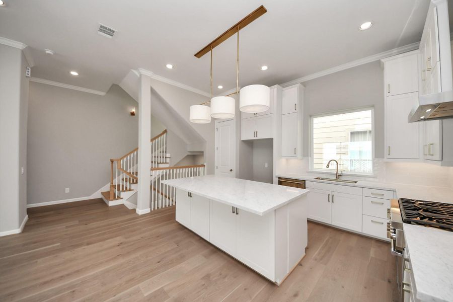 Alternate view of the kitchen showcasing custom cabinetry, premium finishes, and open-concept design. Alternate view of the kitchen showcasing custom cabinetry, premium finishes, and open-concept design.