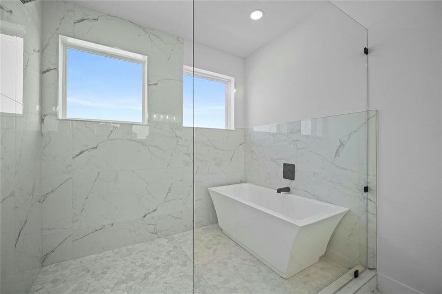 Full bathroom with a freestanding tub, a marble finish shower, tile walls, and recessed lighting
