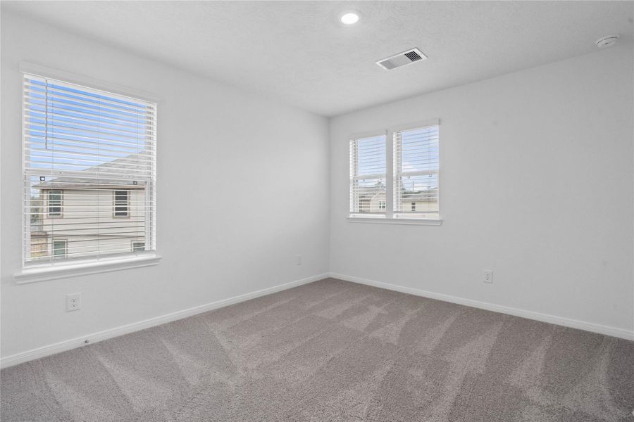 Enjoy an additional private space in this comfortable secondary bedroom. The room is filled with natural light, offers plenty of storage in the closet, and is perfectly positioned for quiet and relaxation.