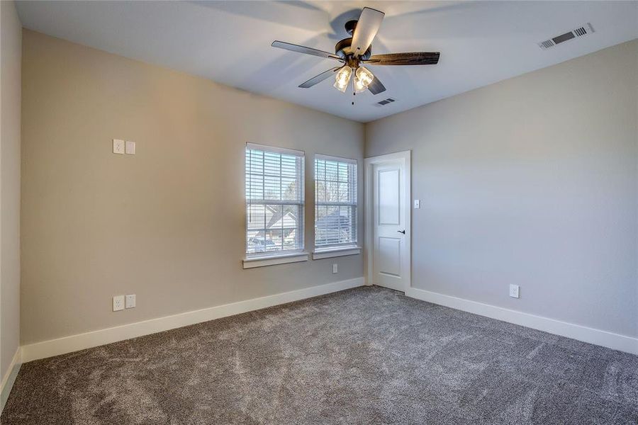 Carpeted spare room with ceiling fan