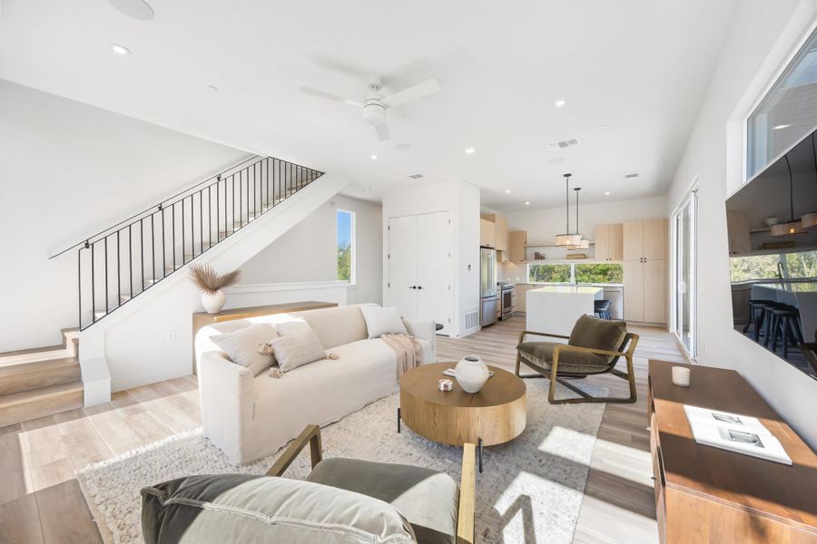 Living area featuring recessed lighting, light wood-style floors, stairway, and a ceiling fan Living area featuring recessed lighting, light wood-style floors, stairway, and a ceiling fan