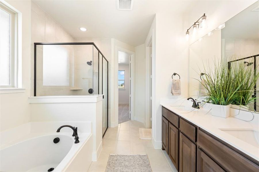 Bathroom featuring double vanity, a garden tub, a stall shower, light tile patterned floors, and recessed lighting