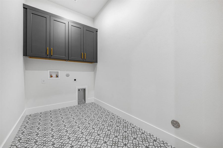 Washroom with electric dryer hookup, washer hookup, cabinet space, and baseboards. Washroom with electric dryer hookup, washer hookup, cabinet space, and baseboards.