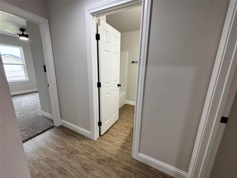 Hallway with baseboards and light wood finished floors