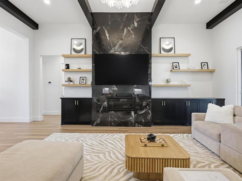 Living area featuring a floor-to-ceiling black marble-look fireplace surround with an integrated firebox