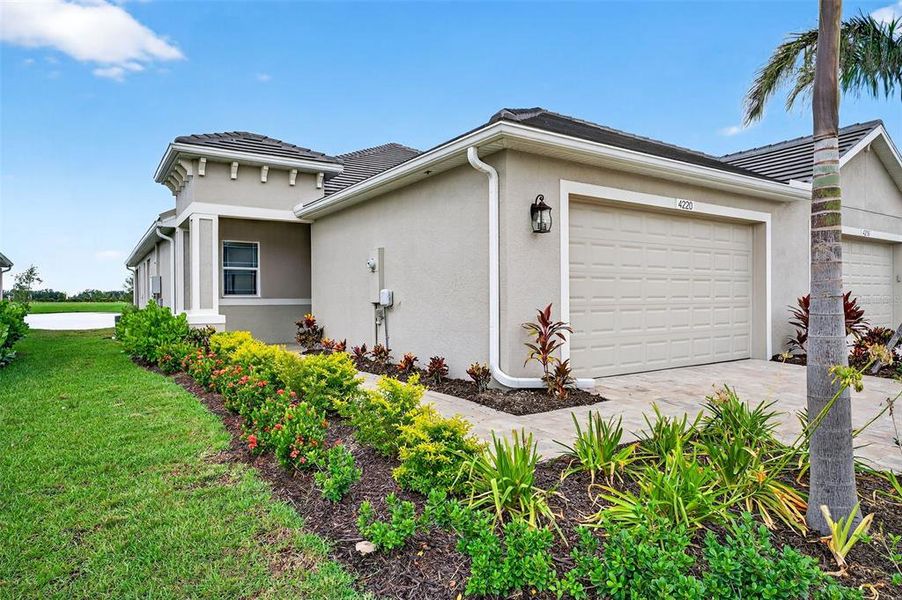 Front exterior of a new home in The Laurels Villas, Parrish, FL, highlighting curb appeal (Image 1).