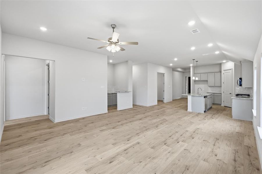 Open-concept living space featuring wood-finish flooring, recessed lighting, and a ceiling fan Open-concept living space featuring wood-finish flooring, recessed lighting, and a ceiling fan