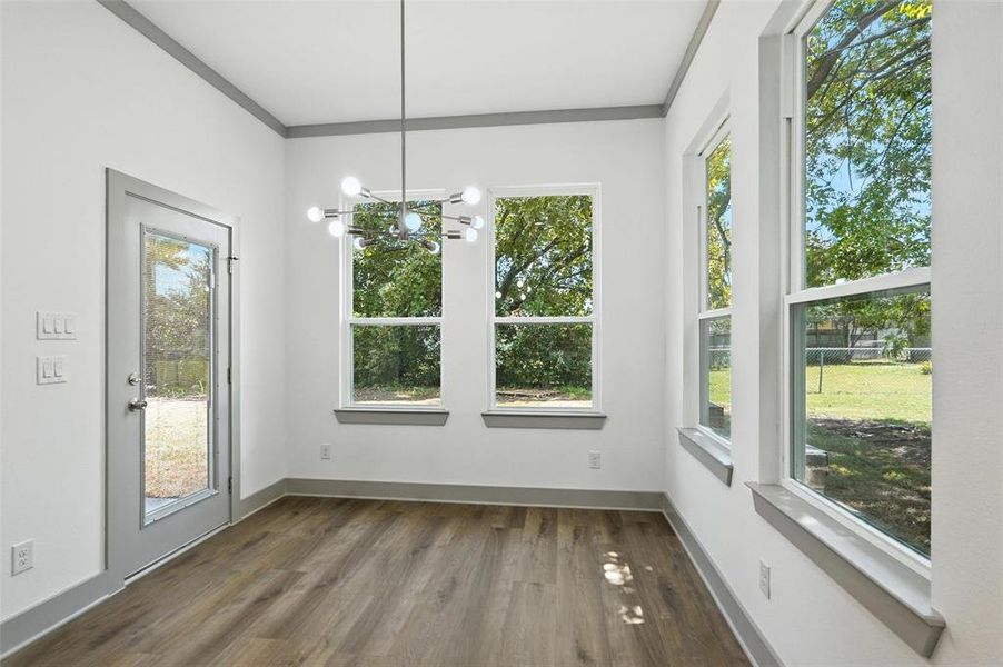 Unfurnished dining area featuring a chandelier and dark wood finished floors Unfurnished dining area featuring a chandelier and dark wood finished floors