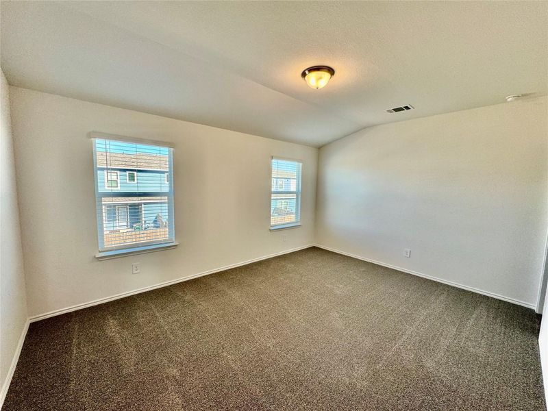Carpeted spare room with lofted ceiling and a textured ceiling