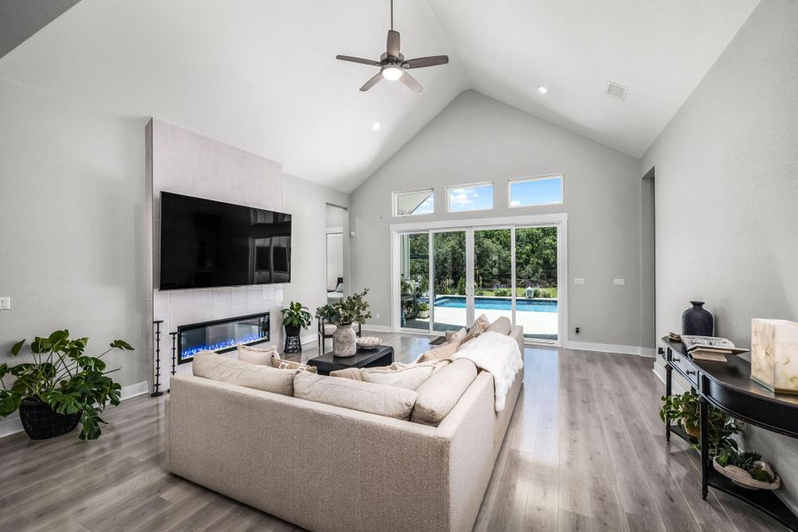 A spacious living area with vaulted ceilings and large sliding glass doors opens to a refreshing outdoor pool.