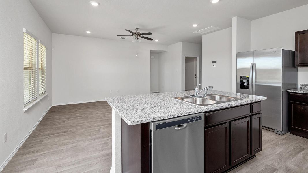 Kitchen featuring dark wood finish cabinets, stainless steel appliances, ceiling fan, light wood-style flooring, and recessed lighting