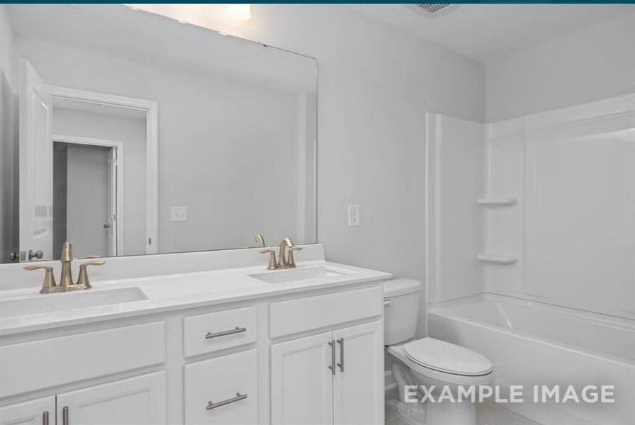Bathroom with toilet, a sink, double vanity, and shower / bathing tub combination