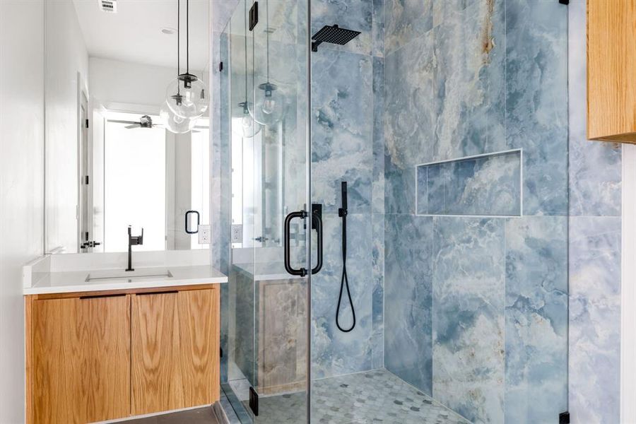 Bathroom featuring a marble finish shower and vanity Bathroom featuring a marble finish shower and vanity