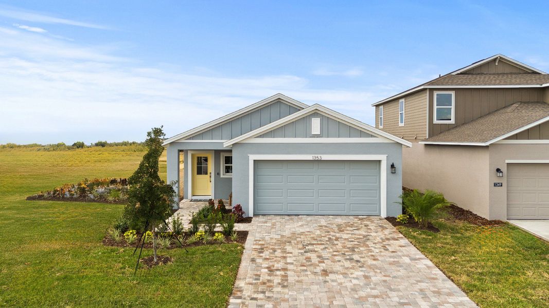 The Atlantic at Hamilton Bluff showcases a charming exterior with lush landscaping, 2-car garage, and elegant paver driveway.