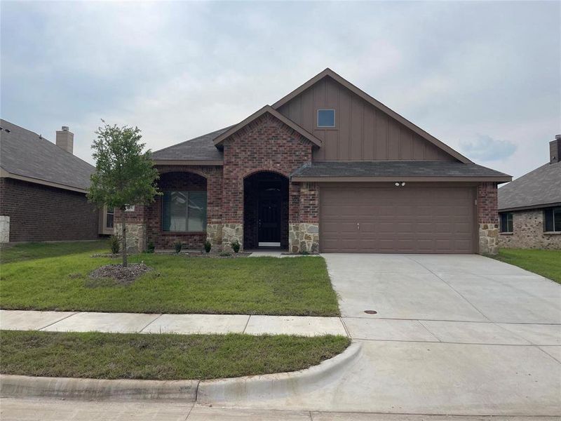 View of front of house featuring a front yard and a garage