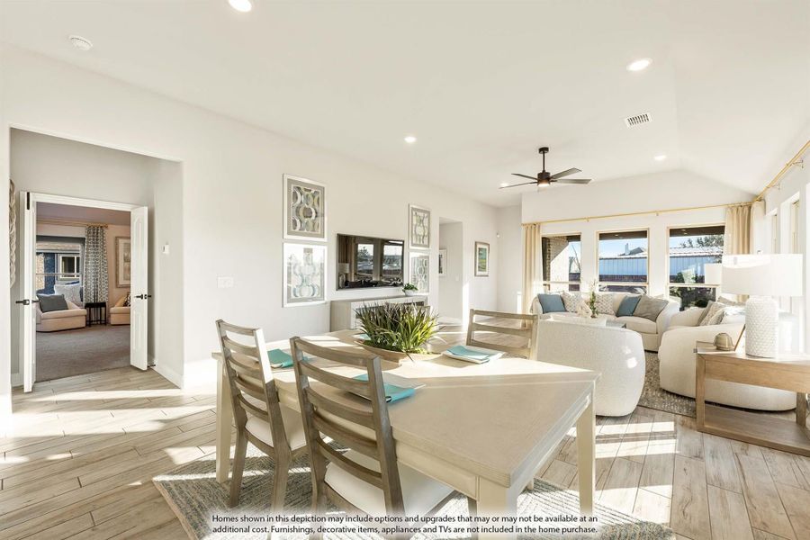 Open-plan dining and living area with light wood floors, ceiling fan, and neutral furnishings Open-plan dining and living area with light wood floors, ceiling fan, and neutral furnishings