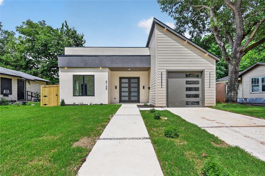 Contemporary exterior featuring a flat roofline and a sharply angled gable roof, a modern garage door with rectangular window inserts, and a dual-panel glass entry door Contemporary exterior featuring a flat roofline and a sharply angled gable roof, a modern garage door with rectangular window inserts, and a dual-panel glass entry door