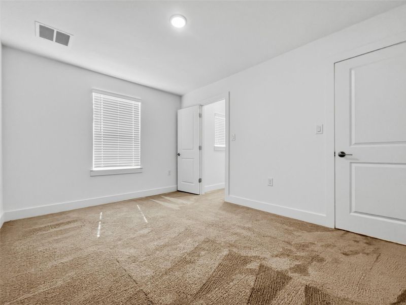 Bedroom featuring light colored carpet and baseboards