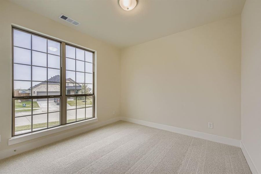 Empty room featuring light carpet and baseboards