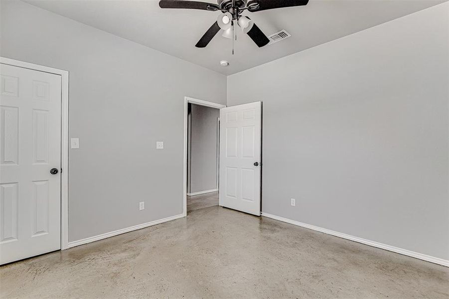 Unfurnished room with concrete floors and ceiling fan