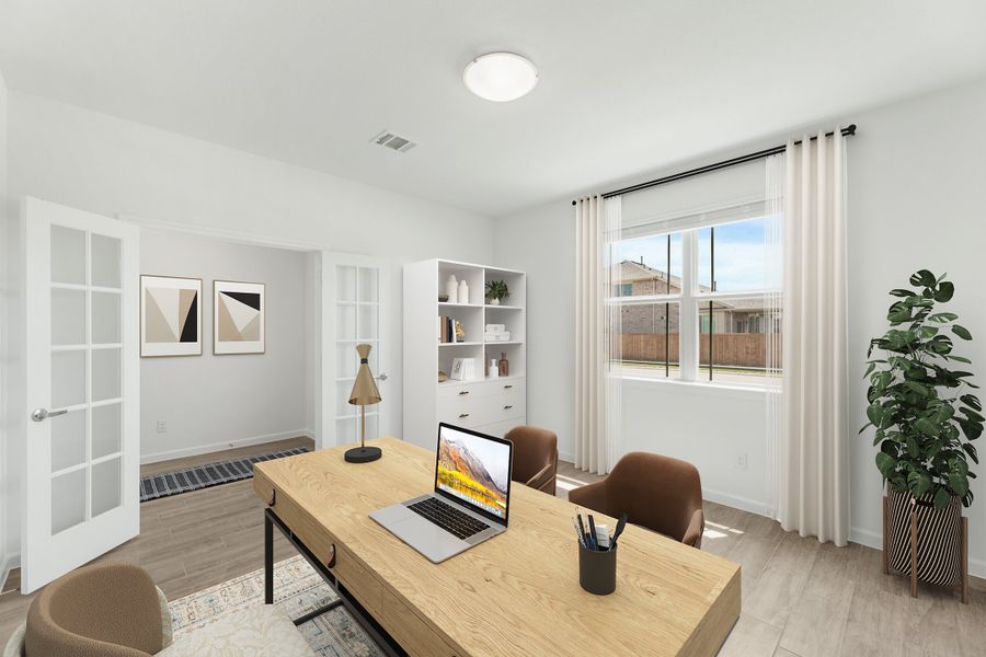 Home office with wood desk, laptop, white shelving, and French doors on light hardwood floors