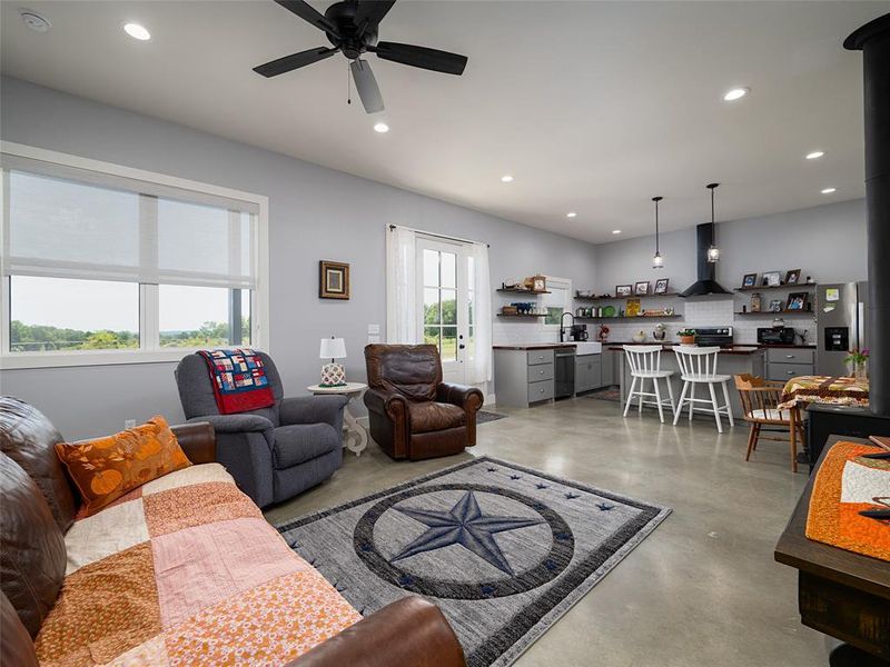 Living room featuring concrete flooring, recessed lighting, and a ceiling fan Living room featuring concrete flooring, recessed lighting, and a ceiling fan