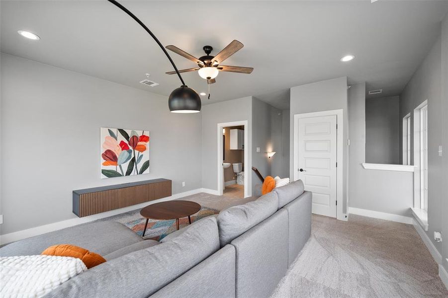 Carpeted living room with ceiling fan