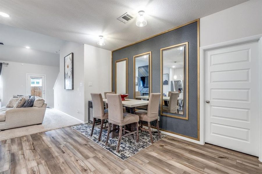 Dining space with light wood-style floors and recessed lighting