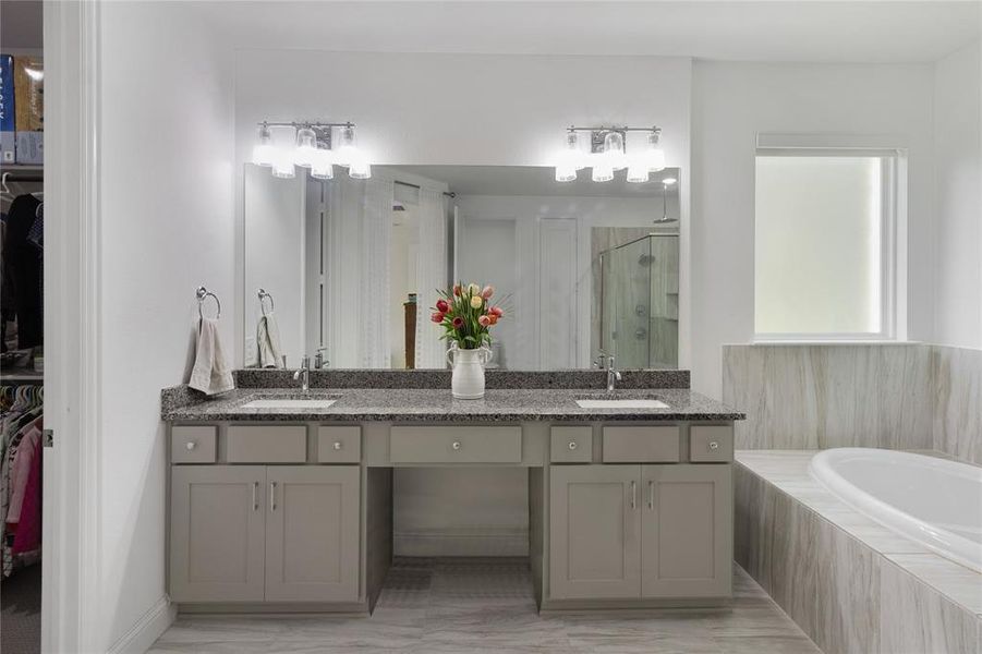 Bathroom featuring a dual vanity with a granite countertop, undermount sinks, and contemporary light fixtures