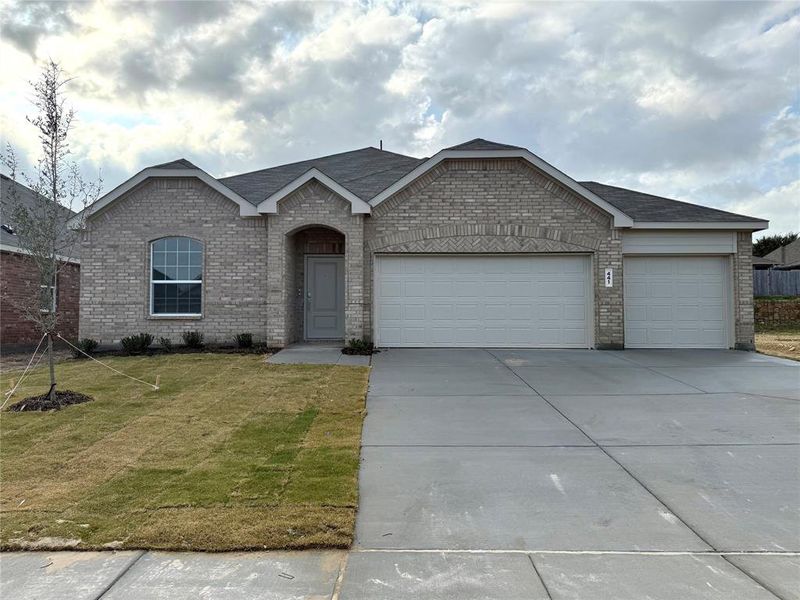 View of front of home featuring a front yard and a garage