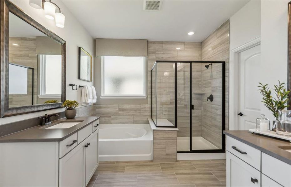Modern owner's bath with dual vanities and a spacious shower *Model representation