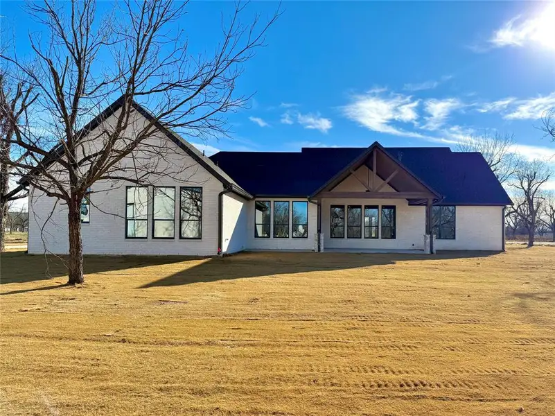 Rear view of house featuring brick siding, a yard, and a patio area Rear view of house featuring brick siding, a yard, and a patio area