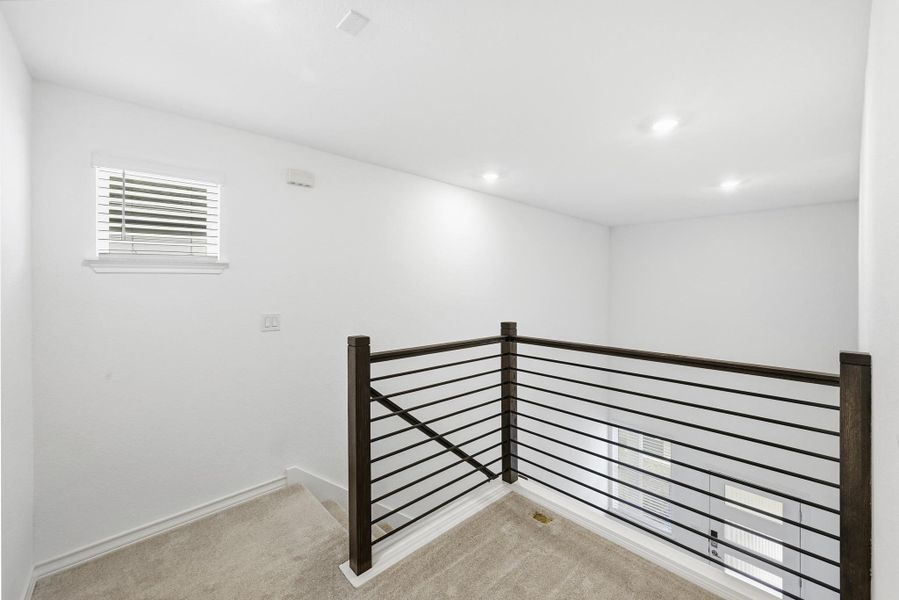 Corridor featuring an upstairs landing, light carpet, and recessed lighting