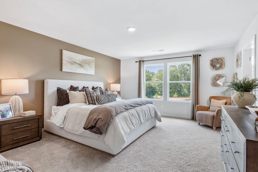 A bedroom with a bed and a chair. A bedroom with a bed and a chair.