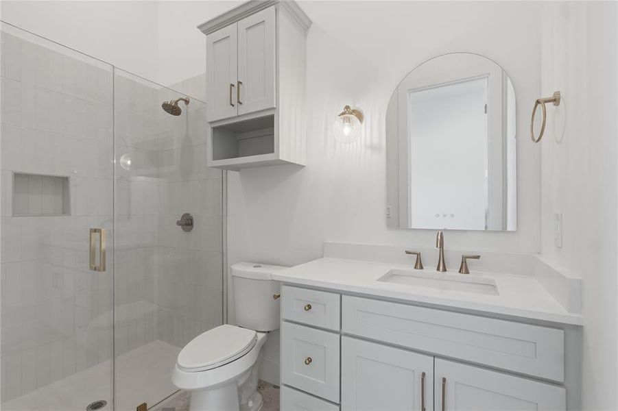 Bathroom featuring a glass-enclosed shower with tile surround, a built-in shower niche, and brushed nickel fixtures