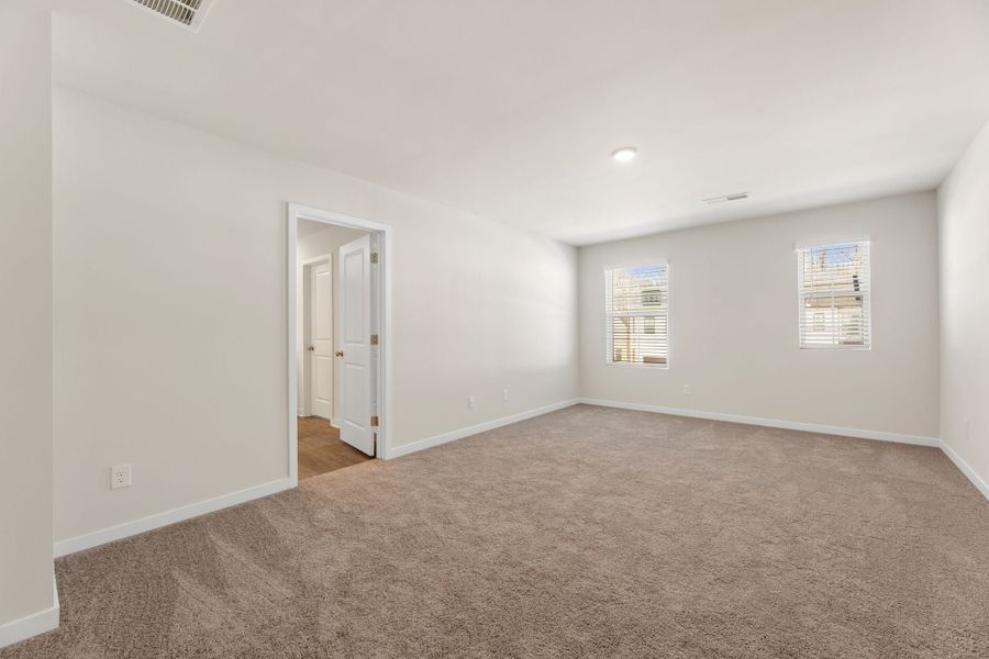 A hallway with carpet and a door. A hallway with carpet and a door.