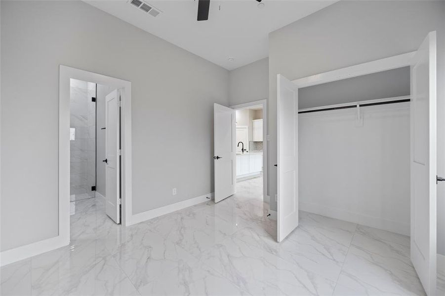 Unfurnished bedroom with visible vents, baseboards, ceiling fan, a closet, and marble finish floor