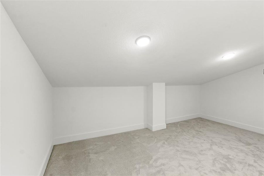 Bonus room with light colored carpet and vaulted ceiling Bonus room with light colored carpet and vaulted ceiling