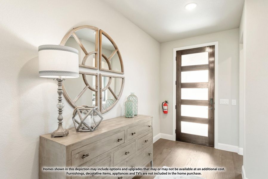 Home entryway with dark wood front door, wood dresser, round decorative mirror, and hardwood floors Home entryway with dark wood front door, wood dresser, round decorative mirror, and hardwood floors