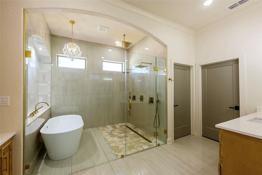 Full bath with vanity, a stall shower, a freestanding bath, recessed lighting, and light tile patterned floors Full bath with vanity, a stall shower, a freestanding bath, recessed lighting, and light tile patterned floors