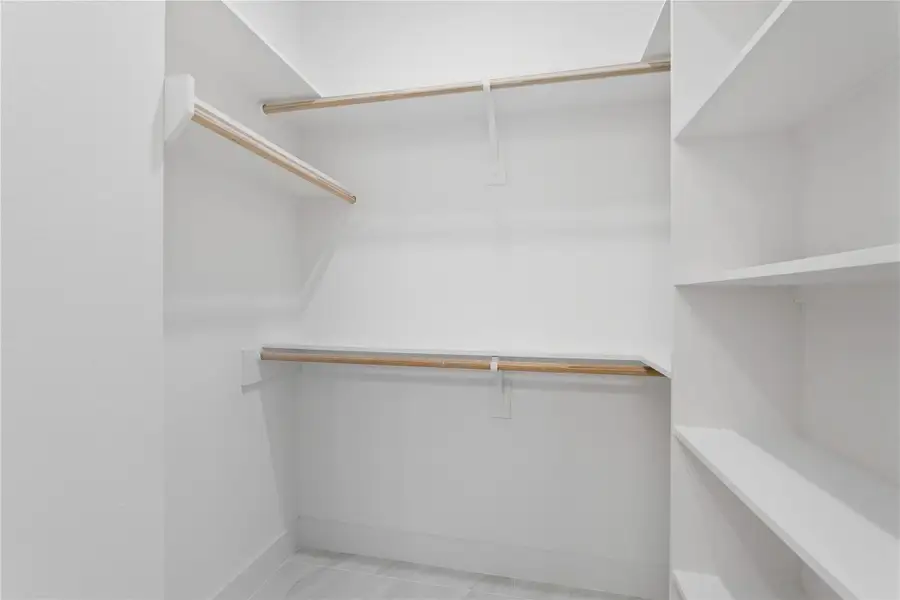 The primary suite features a spacious walk-in closet designed to keep everything organized and within easy reach. With built-in shelving and double hanging rods, there’s plenty of room for your clothing, shoes, and everything in-between. No more fighting for closet space!
