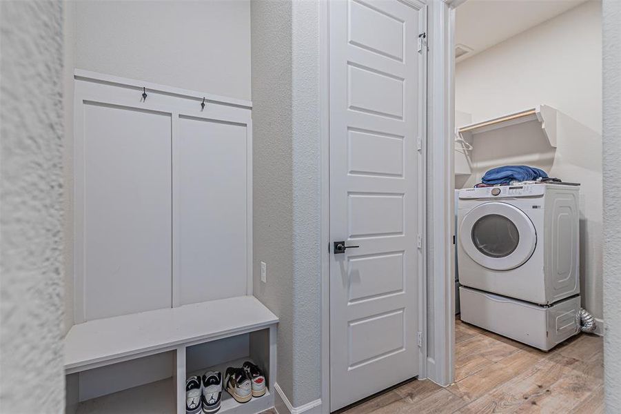 Mudroom area featuring a built-in bench, integrated storage, and wall hooks