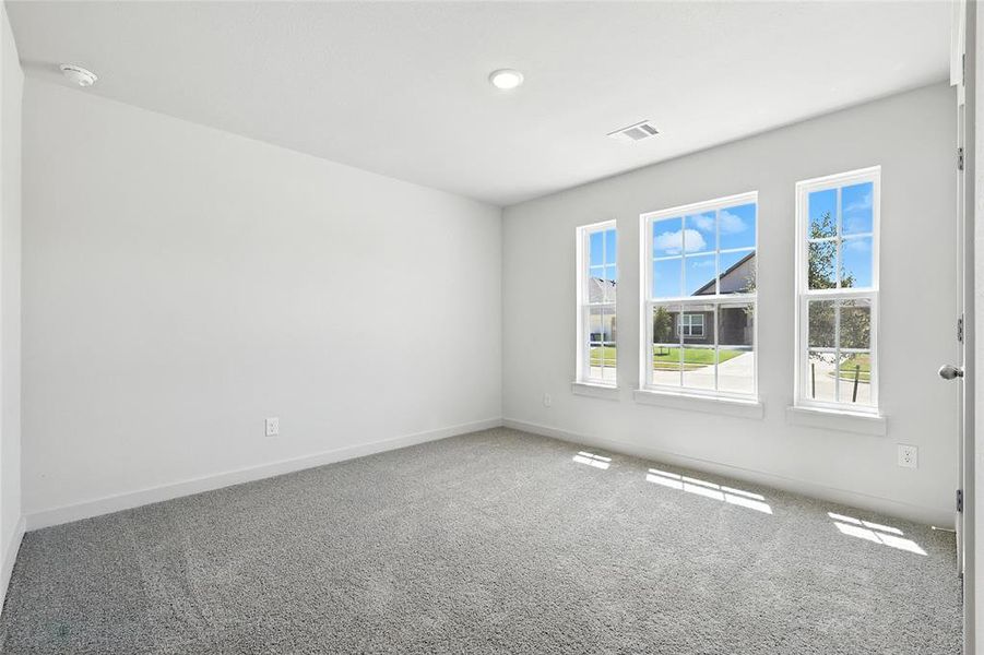 Empty room with carpet floors and a smoke detector