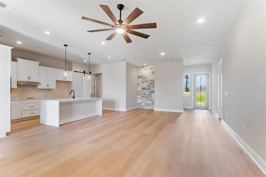 Unfurnished living room with a ceiling fan, light wood-style flooring, and recessed lighting