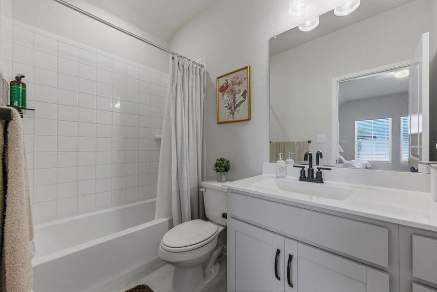 Bathroom with shower / bath combo with shower curtain and vanity