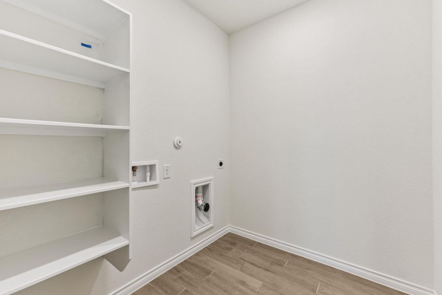 Laundry area with wood finish floors, gas dryer hookup, electric dryer hookup, and hookup for a washing machine Laundry area with wood finish floors, gas dryer hookup, electric dryer hookup, and hookup for a washing machine