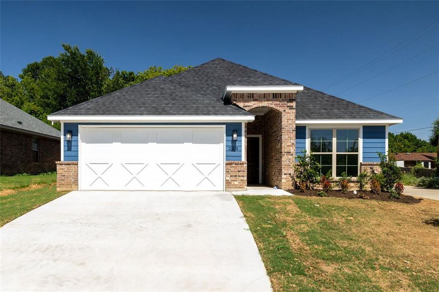 View of front of house featuring a garage and a front lawn