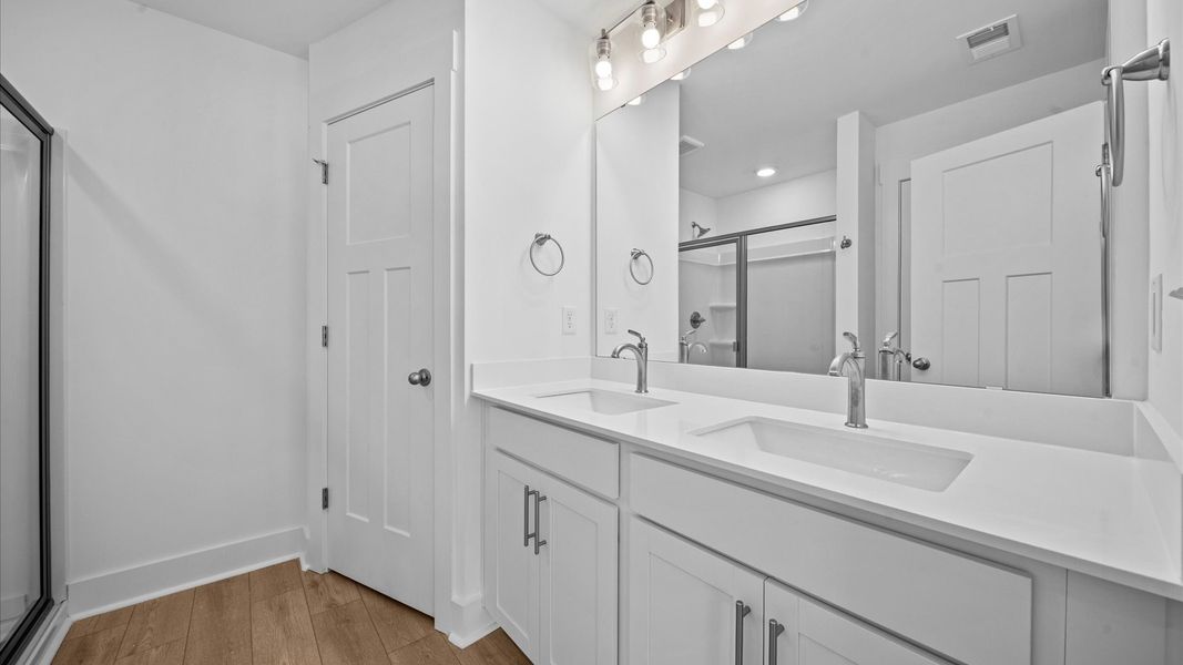 Accomplished design shines in this primary bath with dual vanity and a sleek walk-in shower Accomplished design shines in this primary bath with dual vanity and a sleek walk-in shower