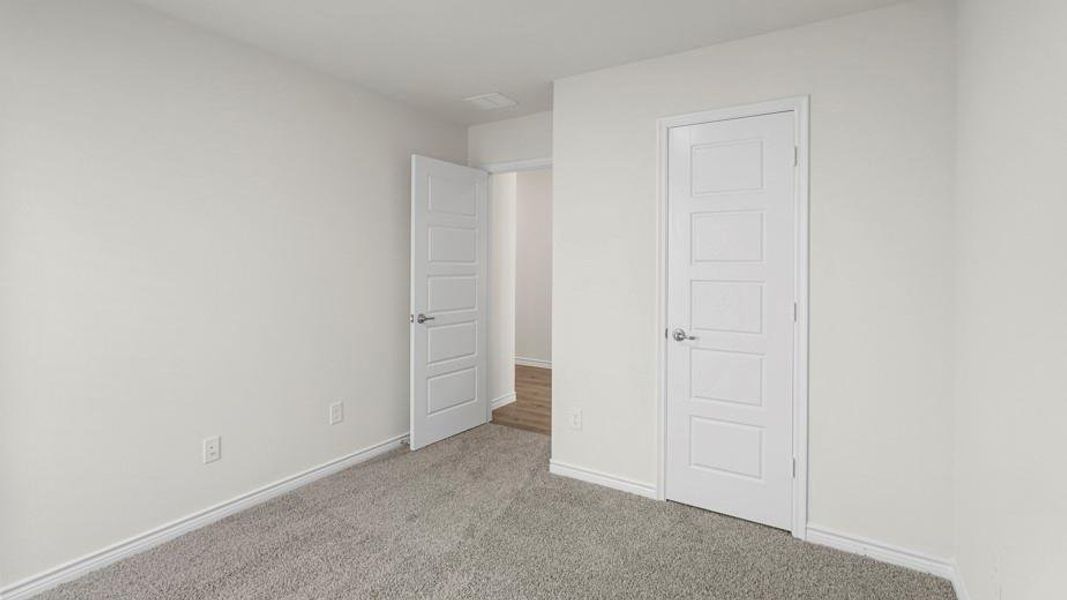 Neutral-toned walls complement plush grey carpeting